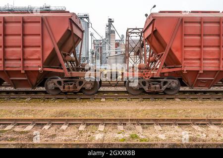 Vue du terminal de grain à travers les deux trains en vrac reliés entre eux. Wagons de chemin de fer pour le transport de grain. Banque D'Images