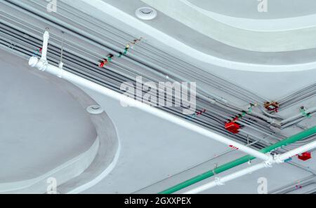 Système de conduits électriques et tuyau en acier galvanisé de câble électrique installé au plafond. Système automatique de sécurité sprinkleur avec tuyau blanc. Unité commerciale Banque D'Images