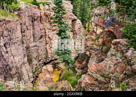 Passerelle en métal donnant sur de grandes gorges dans les montagnes avec rivière jaune Banque D'Images