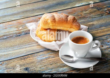 Vue de dessus. Tasse de café expresso italien chaud et croissants sur fond de bois rustique bleu clair. Nourriture et boissons. Style de vie. Banque D'Images