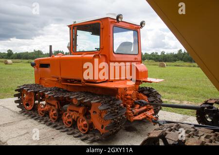 Ancien tracteur à chenilles rouge à proximité du champ Banque D'Images