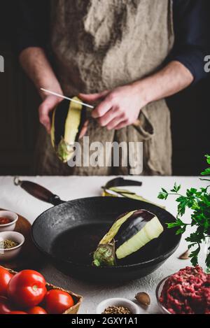 Préparation des aubergines pour la cuisson et la farce avec du bœuf haché et tomates Banque D'Images