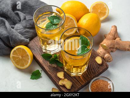 Thé réchauffant avec du citron et du gingembre dans deux verres sur fond gris.Gros plan. Banque D'Images