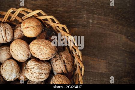 Les noix dans le panier sur planche en bois Banque D'Images