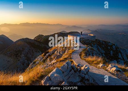 Scène de coucher de soleil au mausolée de Njegos sur la montagne Lovcen, Monténégro, Europe. Personne regardant les montagnes. Banque D'Images