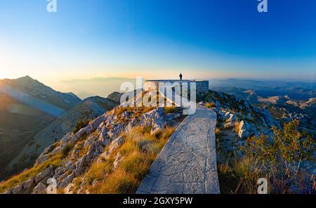 Scène de coucher de soleil au mausolée de Njegos sur la montagne Lovcen, Monténégro, Europe. Personne regardant les montagnes. Banque D'Images