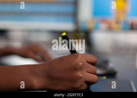 Gros plan de l'image client de l'édition de concepteur noir avec un crayon de stylet, dessin sur une tablette graphique. Main de femme afro-américaine rédactrice photographe retouche des actifs travaillant dans le bureau de la société de production créative Banque D'Images