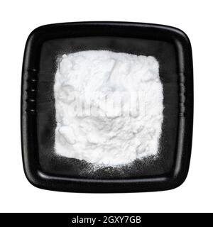 vue de dessus du bicarbonate de sodium dans un bol noir isolé sur arrière-plan blanc Banque D'Images