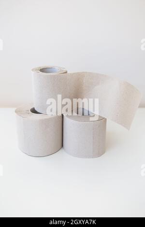 Quelques rouleaux de papier toilette gris sont sur une table blanche. Concept d'hygiène et de propreté Banque D'Images