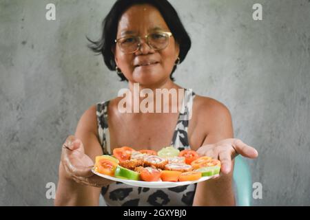 Femme asiatique tenant une assiette de nourriture délicieuse Banque D'Images