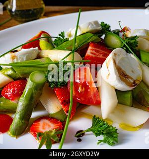 Salade d'asperges avec fraises, tomates et fromage de chèvre Banque D'Images