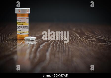 Non-Proprietary Prescription Medicine Bottle et Pills on Reflective Surface en bois. Banque D'Images