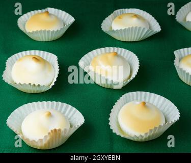 Plusieurs desserts français meringues en silicone moules sur nappe verte Banque D'Images