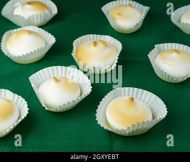 Plusieurs desserts français meringues en silicone moules sur nappe verte Banque D'Images