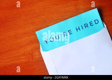 Enveloppe blanche et papier bleu avec du texte QUE VOUS ÊTES LOUÉ sur une table en bois Banque D'Images