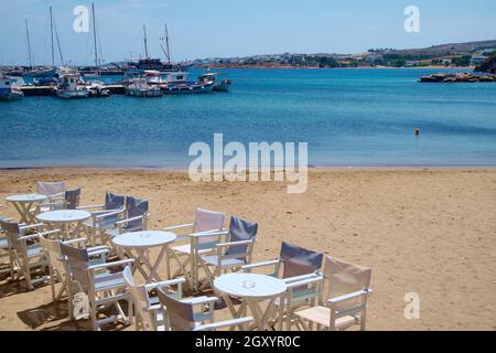 Piso Livadi, île de Paros, Grèce. Vue sur la plage. Tables et chaises sur le sable dans une charmante baie. Vue paysage avec espace de copie Banque D'Images