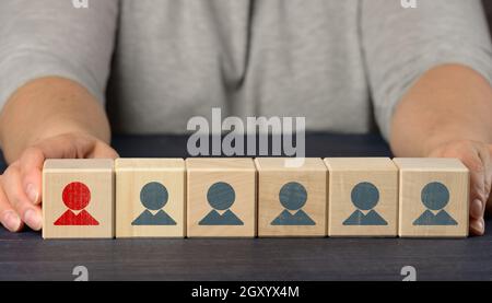 les mains des femmes tiennent des cubes en bois avec des figurines. Concept de recherche d'employés, recrutement de personnel. Sélection d'employés talentueux et uniques pour l'advane de carrière Banque D'Images