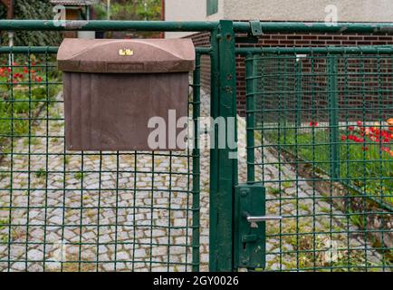 ancienne boîte aux lettres sur la clôture devant la maison. Banque D'Images