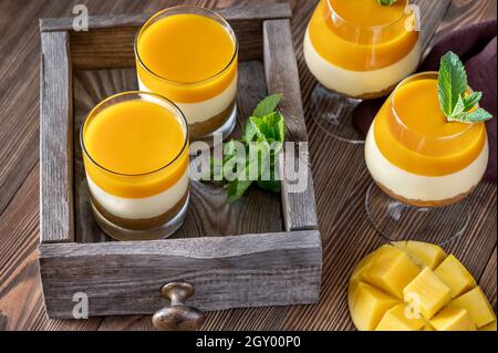 Cheesecake à la mangue servi dans les verres sur fond rustique Banque D'Images