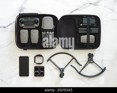 Drone pliant.Équipement de drone avec jeu complet sur fond de marbre blanc.Style minimaliste.Vue de dessus.Pose à plat.Kit de drone UAV en étui et accessoires. Banque D'Images
