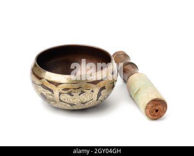 bol chantant en laiton et maillet en bois isolé sur fond blanc. Instrument de musique pour la méditation, la relaxation, diverses pratiques médicales liées à Banque D'Images