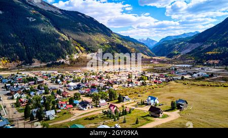Vue au-dessus de la petite ville minière dans la vallée avec arrière-plan de grandes chaînes de montagnes Banque D'Images