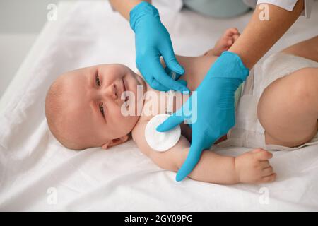 Bébé tranquille et mignon vacciné par un professionnel de la santé Banque D'Images