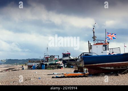 Bateau de pêche britannique battant le drapeau de l'Union Jack sur la plage à Deal, kent avec falaises blanches de Douvres. Banque D'Images