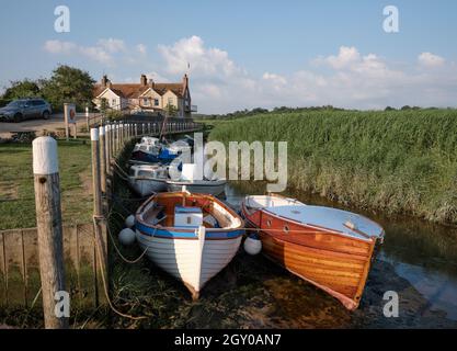 Bateaux sur la petite rivière Glaven à marée basse à CLEY à côté de la mer et les lits de roseaux de CLEY Marshes Norfolk Heritage Coast Angleterre Royaume-Uni Banque D'Images