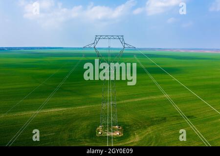 Vue aérienne en gros plan du pylône électrique avec lignes électriques sur le champ agricole. Banque D'Images