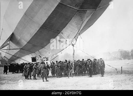 Photo d'époque le 3 avril 1913 d'un navire de classe H Zeppelin IV, ou LZ 16, qui a fait un atterrissage d'urgence sur le terrain de parade de Luneville, en France, après avoir fait peu de carburant. Les soldats français se rassemblent autour du navire Banque D'Images