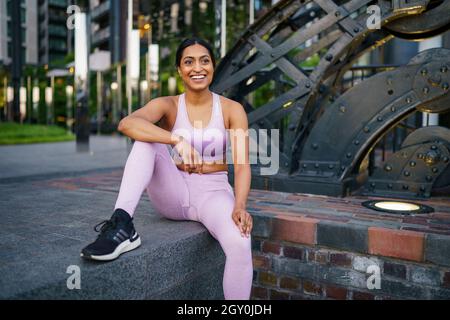 Femme vêtue d'une tenue de sport rose en milieu urbain Banque D'Images