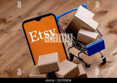 Smartphone avec logo Etsy à l'écran, panier et colis. Banque D'Images