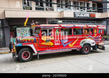 Une jeepney rouge dans les rues de la ville de Baguio, Philippines Banque D'Images