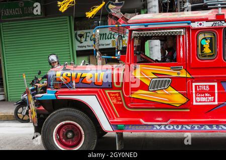 Une jeepney rouge dans les rues de la ville de Baguio, Philippines Banque D'Images