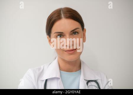 Une photo d'une femme médecin aux cheveux foncés dans une robe blanche Banque D'Images