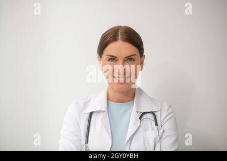 Une photo d'une femme médecin aux cheveux foncés dans une robe blanche Banque D'Images