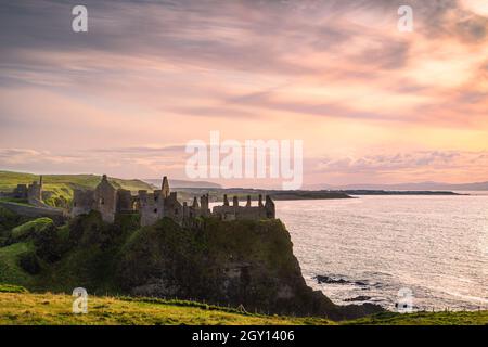 Ciel spectaculaire au-dessus des ruines du château de Dunluce perché au bord de la falaise, Bushmills Irlande du Nord lieu de tournage de la populaire série télévisée Game of Thrones Banque D'Images