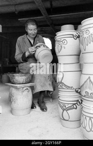 Eine aus dem Töpfermeisterin Steinkrüge bemalt Kannenbäckerland dans der charakteristischen blauen Glasur des Steinguts America, Deutschland 1930 er Jahre. Un maître potter dans les pots en grès, peinture couleur bleue caractéristique de la America grès, Allemagne 1930. Banque D'Images