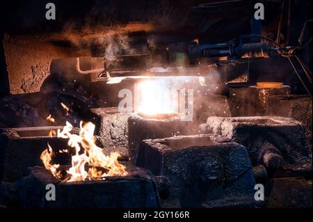 Le métal liquide est versé dans les moules de la louche. Banque D'Images