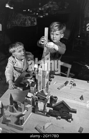 Zwei Jungen spielen am Weihnachtsabend mit den neuen Bauklötzen, Deutschland 1938. Deux garçons jouant avec la nouvelle série de blocs de jouets sous l'arbre de Noël, de l'Allemagne 1930 Banque D'Images