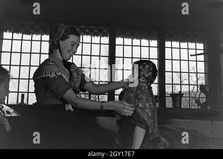 Eine Frau hilft einem kleinen Mädchen beim HANDBRAKE ! der Tracht der Gegend um Ammerland bei Bad Zwischenahn im Oldenburger Land, Deutschland 1930 er Jahre. Une femme d'aider une petite fille à porter le costume traditionnel de Ammerland près de Bad Zwischenahn au Oldenburg, Allemagne 1930. Banque D'Images