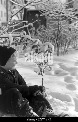 Ein kleiner Junge sitzt im Schnee, Deutschland 1930er Jahre. Un petit garçon assis dans la neige, l'Allemagne des années 1930. Banque D'Images