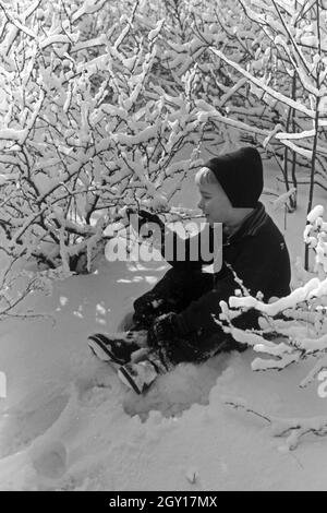 Ein kleiner Junge sitzt im Schnee, Deutschland 1930er Jahre. Un petit garçon assis dans la neige, l'Allemagne des années 1930. Banque D'Images