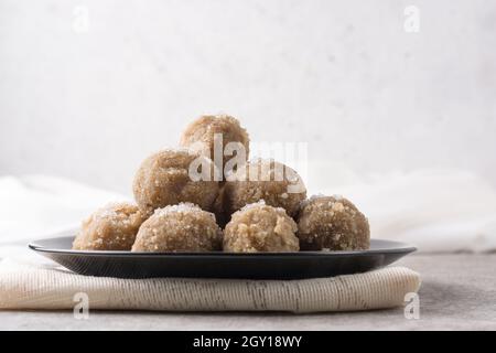 en-cas sucré, boulettes de riz et de noix de coco sur une assiette, sucre saupoudré sur le dessus, dessert sucré ou petit déjeuner Banque D'Images