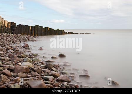 Rochers et groyne en bois à l'entrée du port de Porlock, Porlock Weir, Somerset, Angleterre, Royaume-Uni lors d'une journée d'automne lumineuse et calme. Banque D'Images