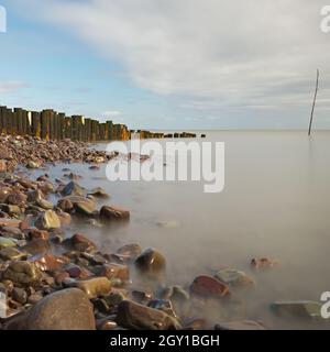 Rochers et groyne en bois à l'entrée du port de Porlock, Porlock Weir, Somerset, Angleterre, Royaume-Uni lors d'une journée d'automne lumineuse et calme. Banque D'Images