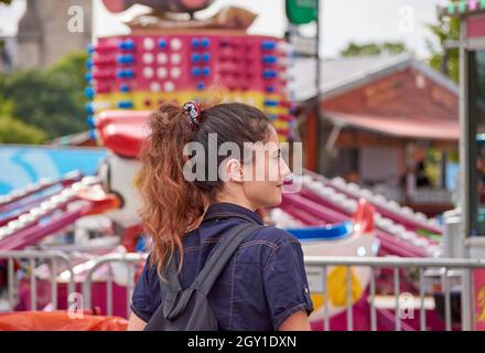 Jeune femme de race blanche marchant dans un parc d'attractions Banque D'Images