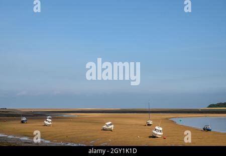 Bateaux de loisirs assis sur un sol sec à marée basse sur la rivière East Fleet et la plage de Wells Next the Sea, Norfolk, Angleterre. Banque D'Images