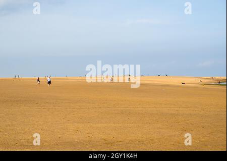 La vie est une plage.Les gens qui marchent au loin sur une grande plage de sable avec beaucoup d'espace, Wells Next the Sea, Norfolk, Angleterre. Banque D'Images